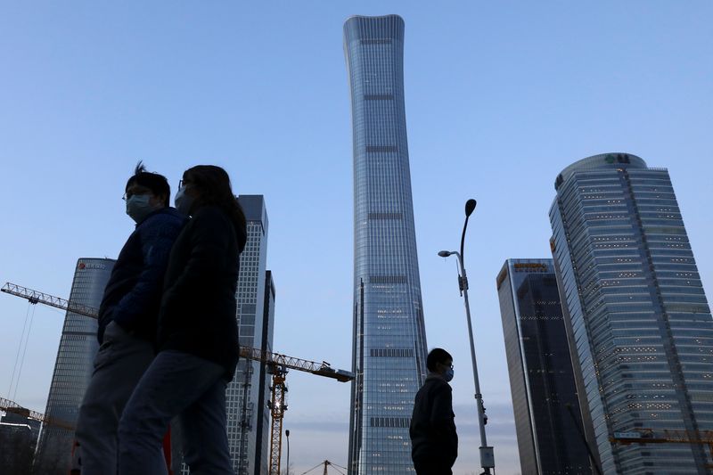 People walk past the Central Business District (CBD) in Beijing