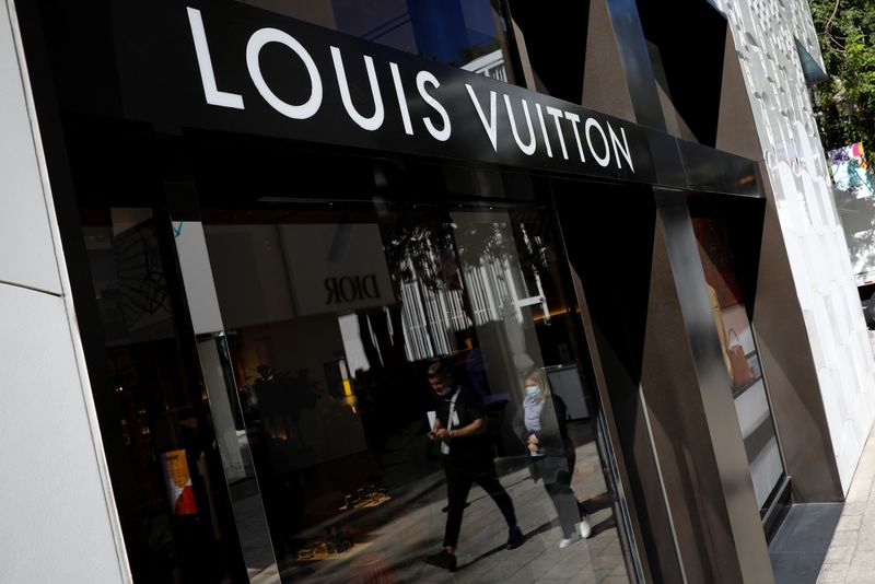 FILE PHOTO: People walk past the Louis Vuitton store at