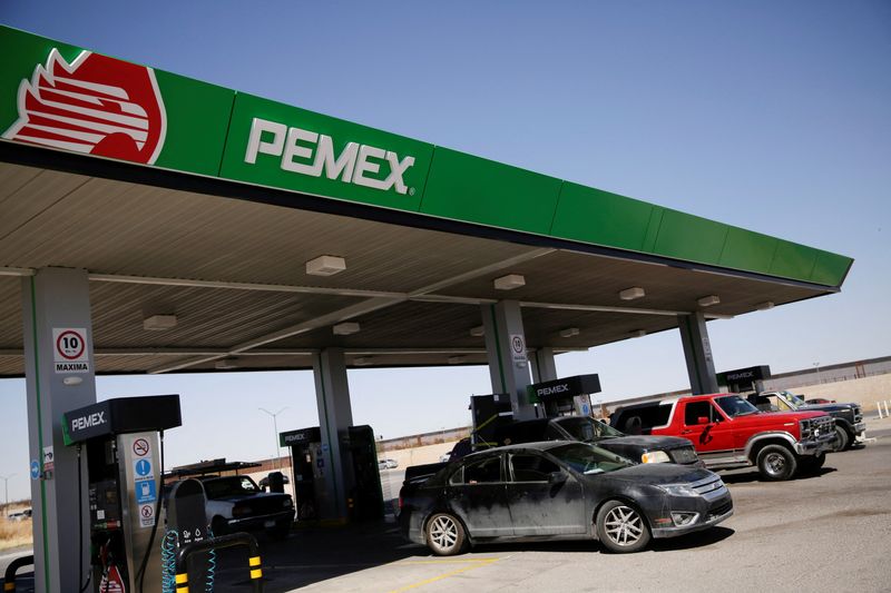 FILE PHOTO: Vehicles are seen next to fuel pumps at