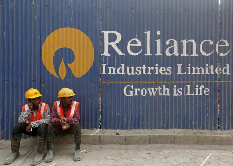 FILE PHOTO: Labourers rest in front of an advertisement of