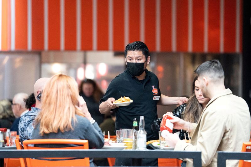 FILE PHOTO: A waiter serves food at a restaurant near