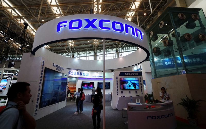Visitors are seen at a Foxconn booth at the World