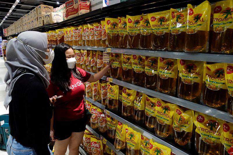 FILE PHOTO: People shop for cooking oil made using palm