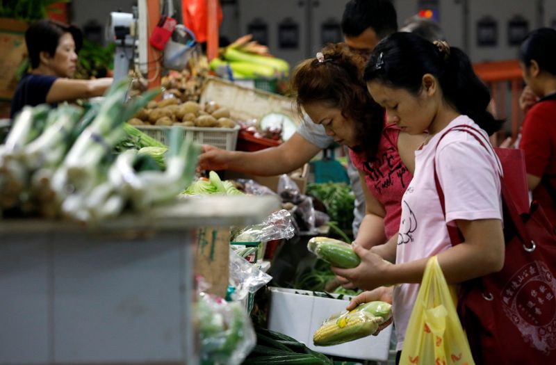 People shop for vegetables at a wet market in Singapore