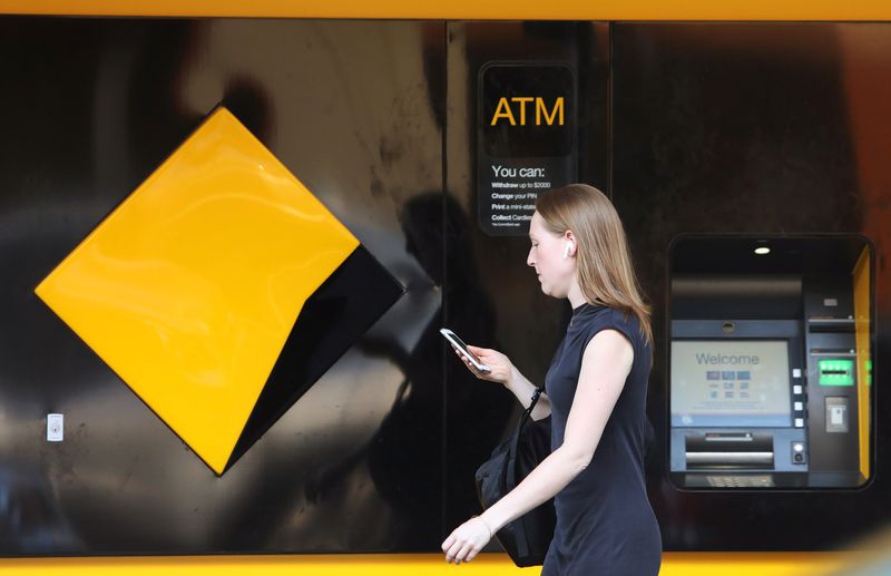 A woman walks past a Commonwealth Bank of Australia logo