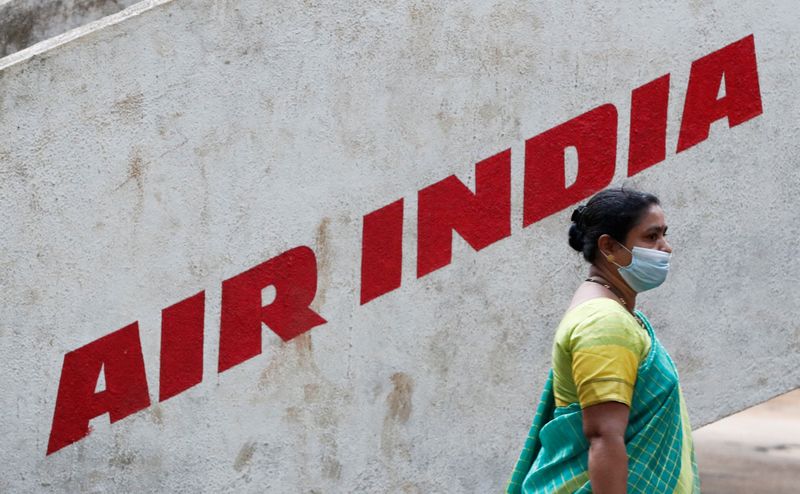 FILE PHOTO: A woman walks past Air India airlines branding