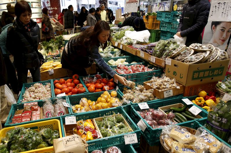 A shopper looks at packs of vegetables at a market