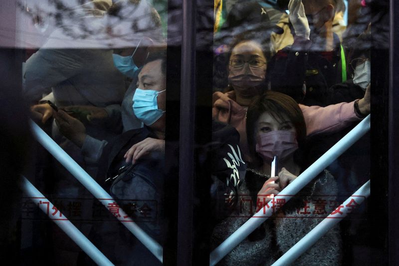 FILE PHOTO: Commuters stand on a bus in the early
