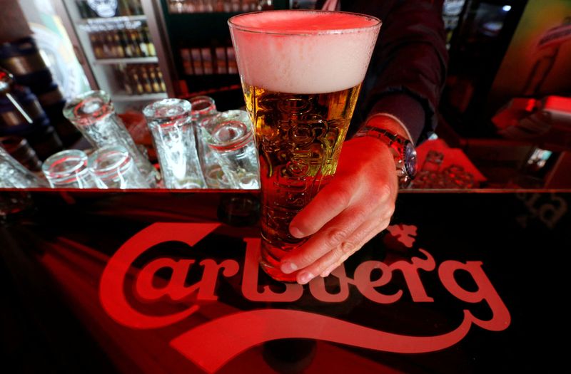 FILE PHOTO: A bartender holds a glass of Carlsberg beer