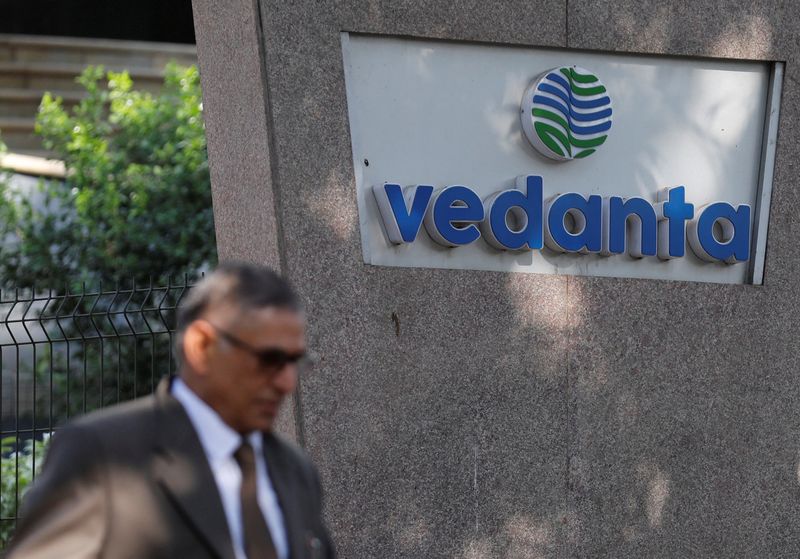 FILE PHOTO: A man walks past the logo of Vedanta