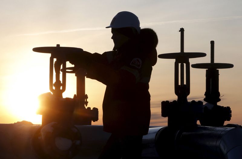 FILE PHOTO: Worker checks valve of oil pipe at Lukoil