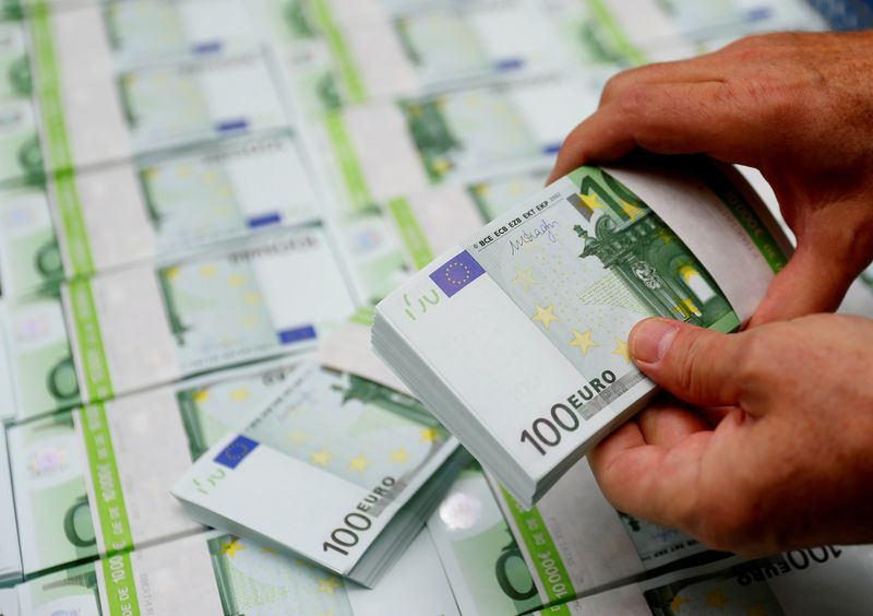 FILE PHOTO: An employee checks 100 Euro banknotes at the
