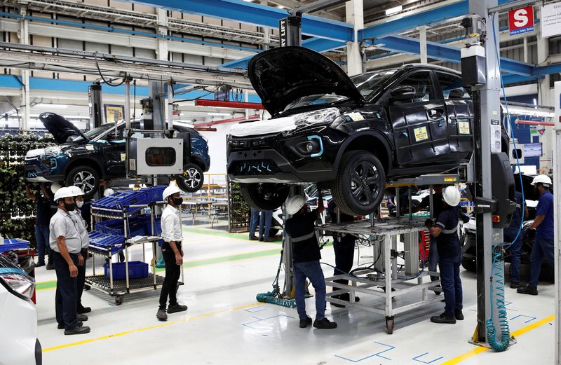 Workers inspect Tata Nexon electric sport utility vehicles (SUV) at