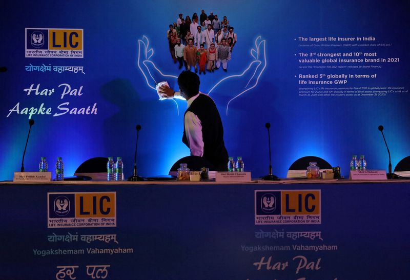 A man cleans a hoarding of Life Insurance Corporation of