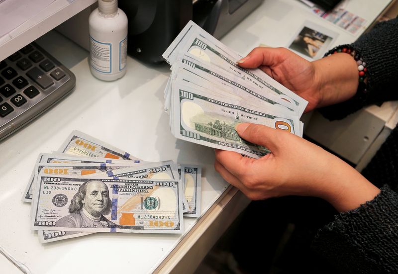 A money changer counts U.S. dollar banknotes at a currency