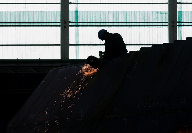 FILE PHOTO: A worker of Italian shipbuilding Fincantieri solders steel
