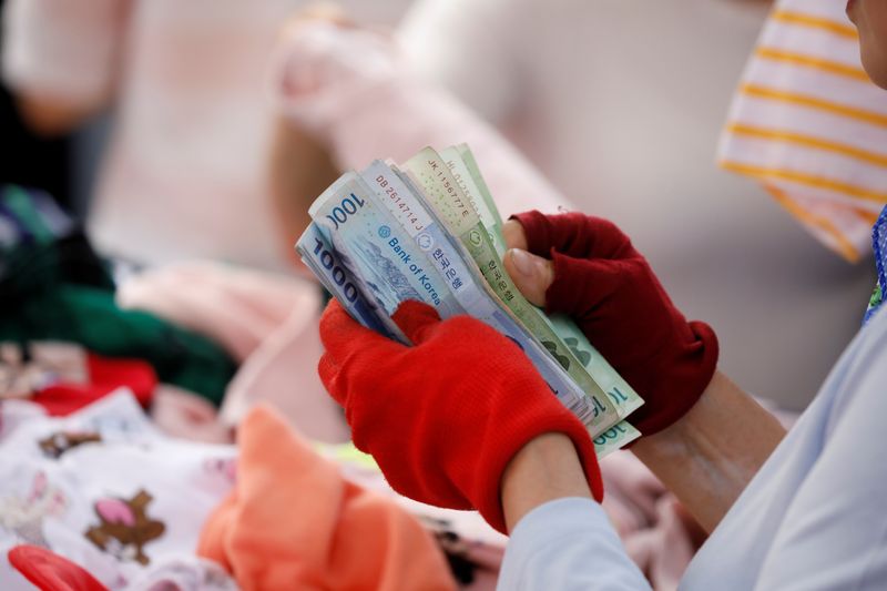 A street vendor counts his money at the Namdaemun Market