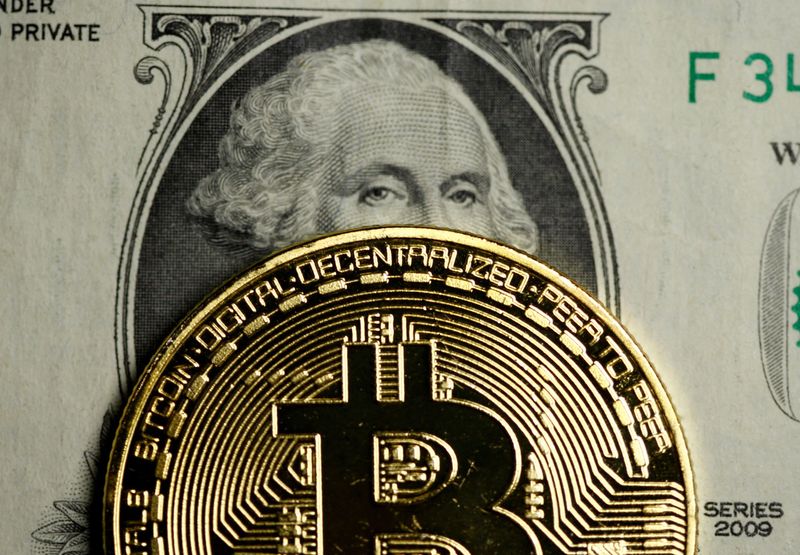 FILE PHOTO: A Bitcoin and Dollar note are seen in
