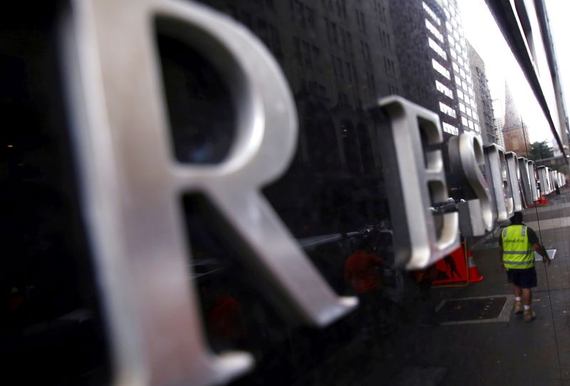 FILE PHOTO: A worker is reflected in a wall of