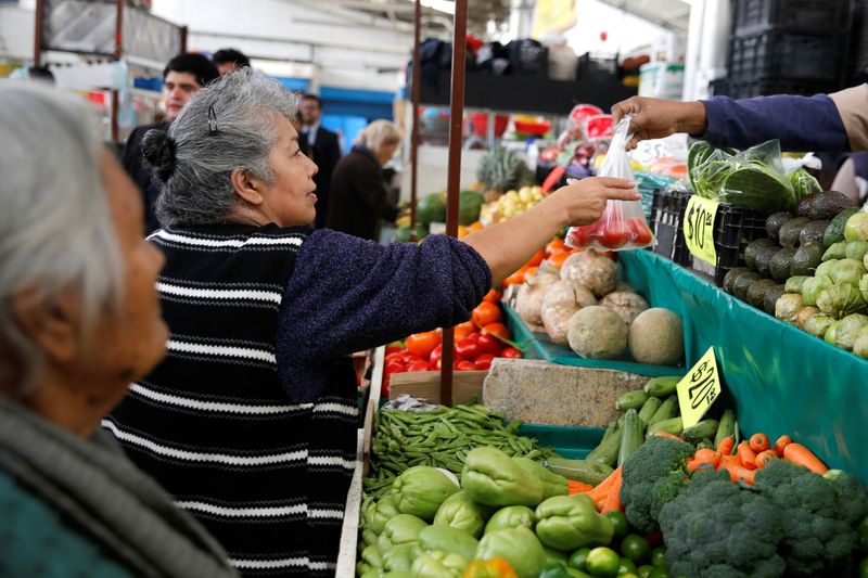 Woman buys tomatoes in a groceries stall at Granada market