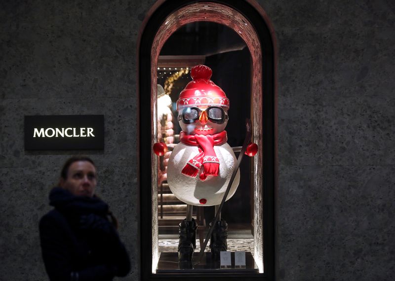 A woman walks past Moncler’s flagship store in Montenapoleone street