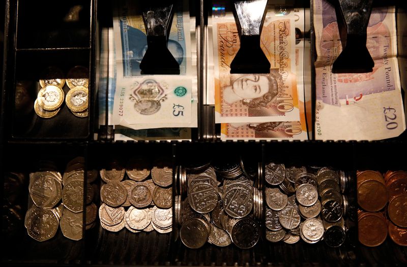 Pound Sterling notes and change are seen inside a cash