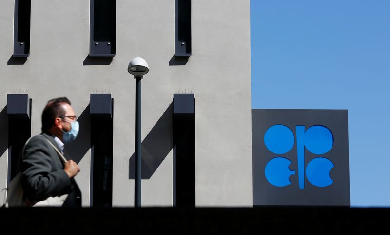 A person passes the OPEC logo in front of its