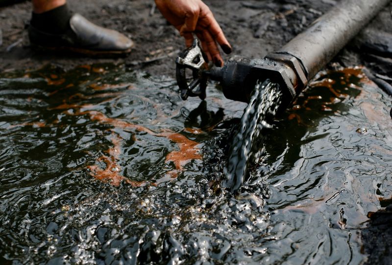 FILE PHOTO: A person operates a tap of crude oil