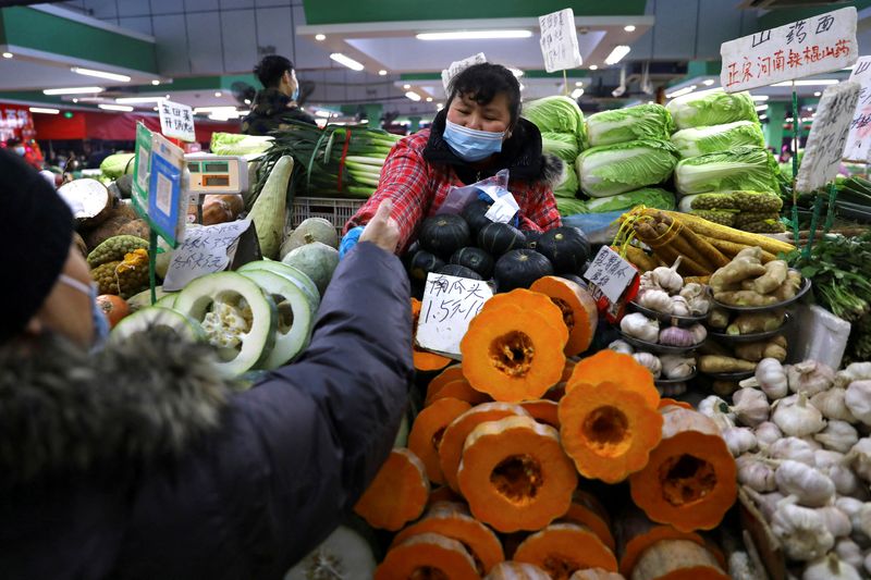 FILE PHOTO: A customer buys vegetables at a stall inside