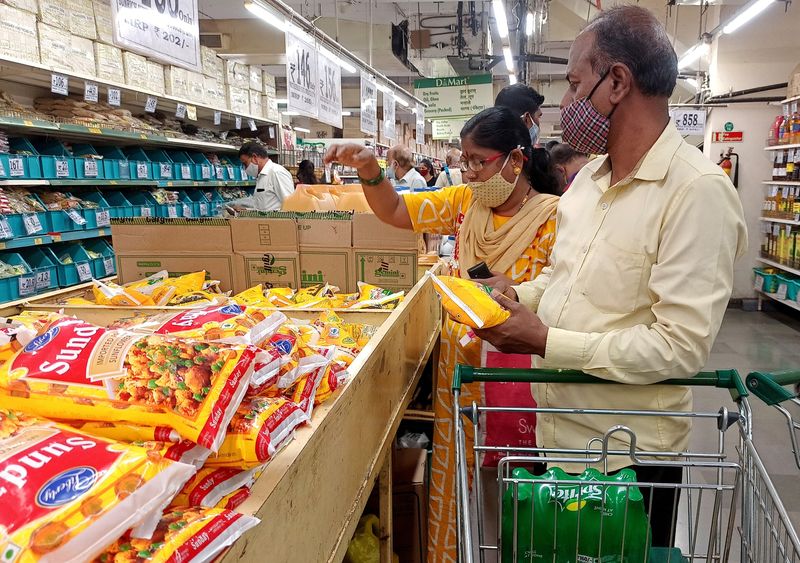 Shoppers purchase packets of vegetable oil at a supermarket in