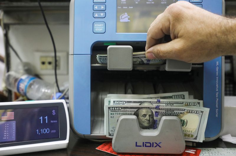 A man counts U.S. dollar banknotes at an exchange shop
