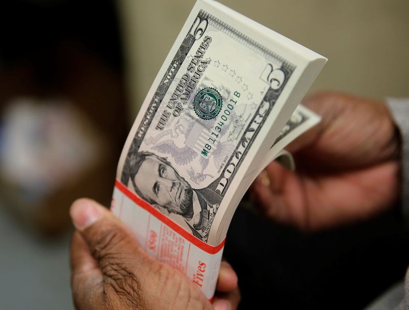 FILE PHOTO: A packet of U.S. five-dollar bills is inspected