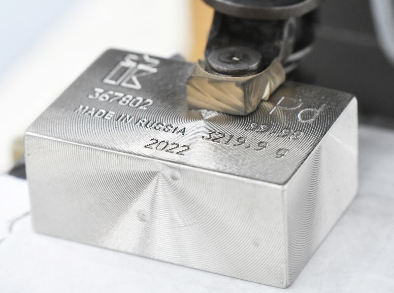 A machine engraves information on an ingot of 99.98 percent