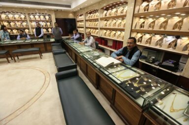 Sales persons wait for customers at a gold jewelry showroom