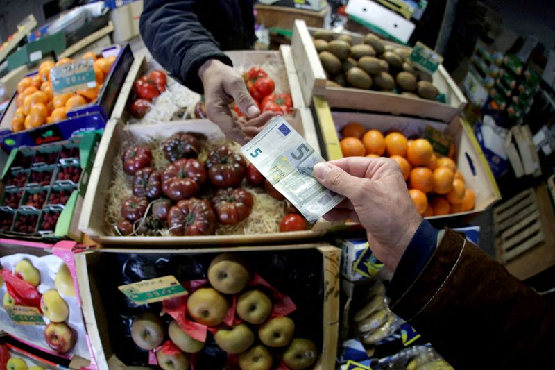 FILE PHOTO: A shopper pays with a Euro bank note