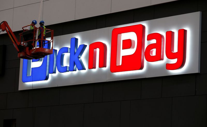 Workers repair a logo of South African retailer Pick n