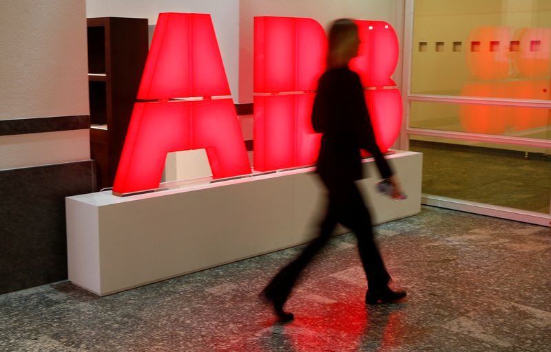 A woman walks past the logo of Swiss power technology