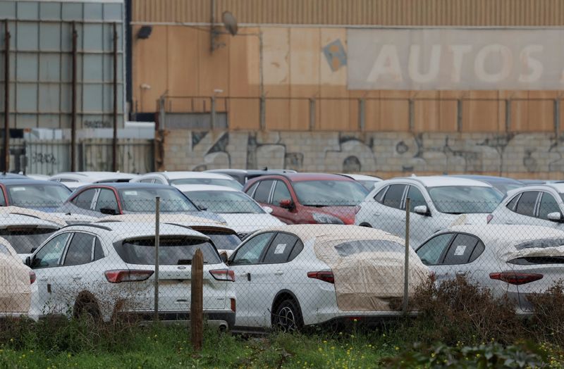 New cars are see parked in a industrial zone in