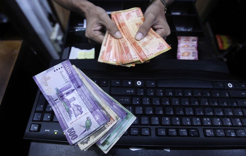 A vendor prepares Sri Lankan notes to bundle them at