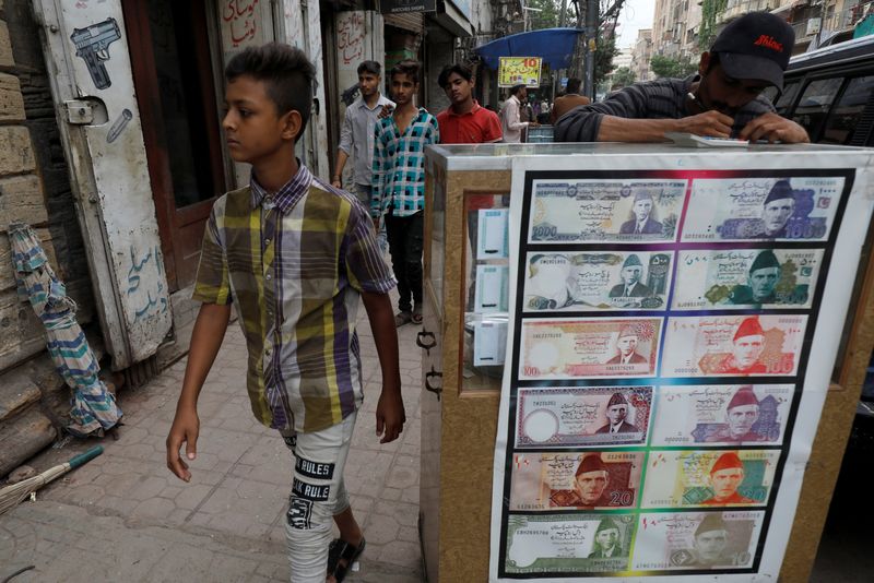 FILE PHOTO: Boy walks past a sidewalk money exchange stall