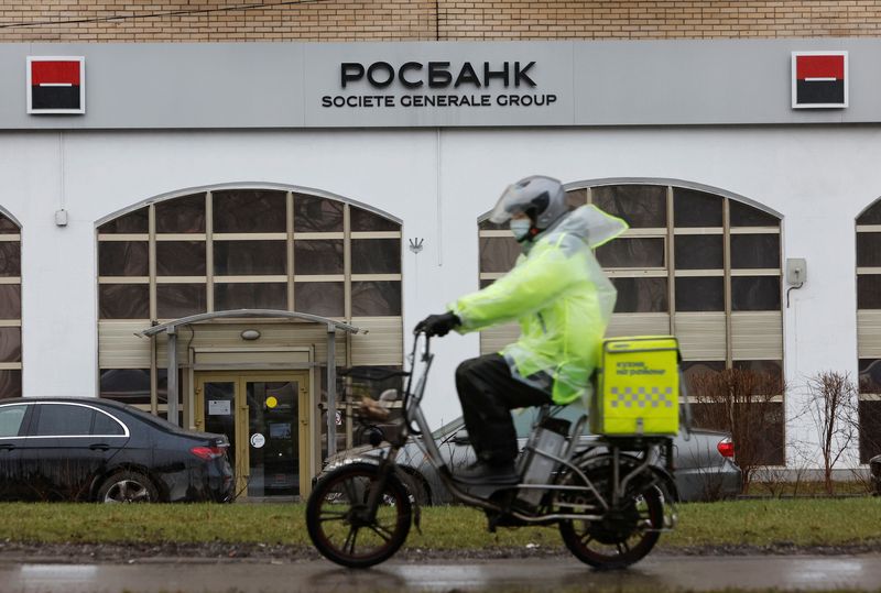 A food delivery courier rides past the Rosbank branch in