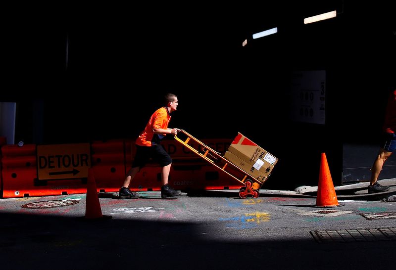 FILE PHOTO – A worker pushes a trolley loaded with