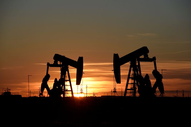 FILE PHOTO: Pump jacks operate at sunset in an oil