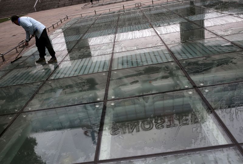 FILE PHOTO: A worker cleans a glass floor reflecting Sinosteel’s