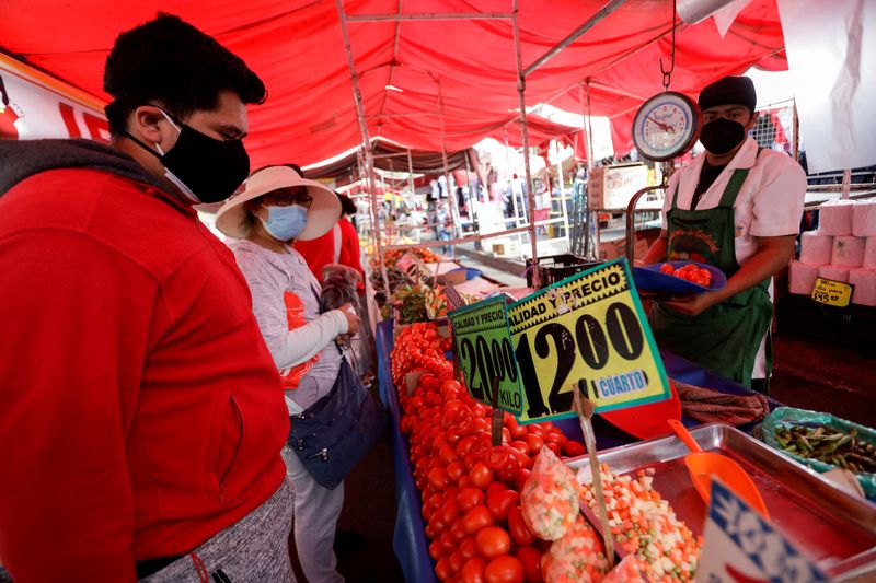 FILE PHOTO: Customers buy tomatoes at a street market, in