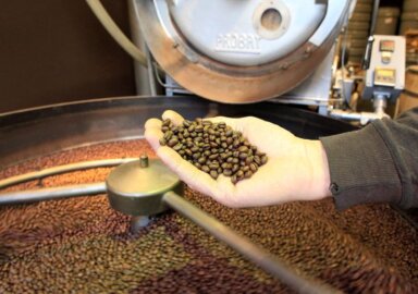 FILE PHOTO: An employee checks freshly roasted coffee beans at