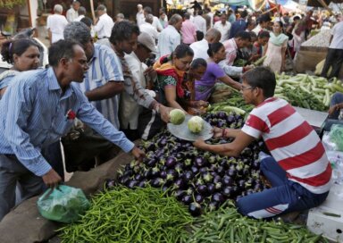 FILE PHOTO: Customers buy vegetables at a market in Ahmedabad