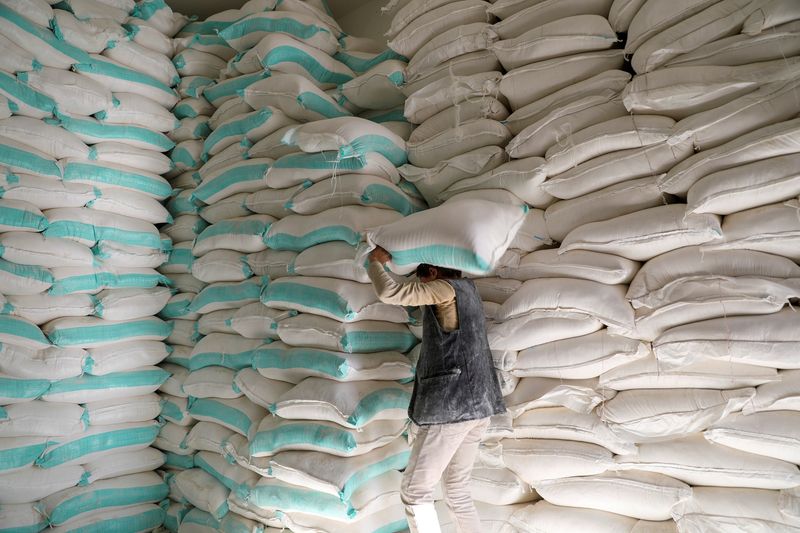 FILE PHOTO: A worker carries a sack of wheat flour