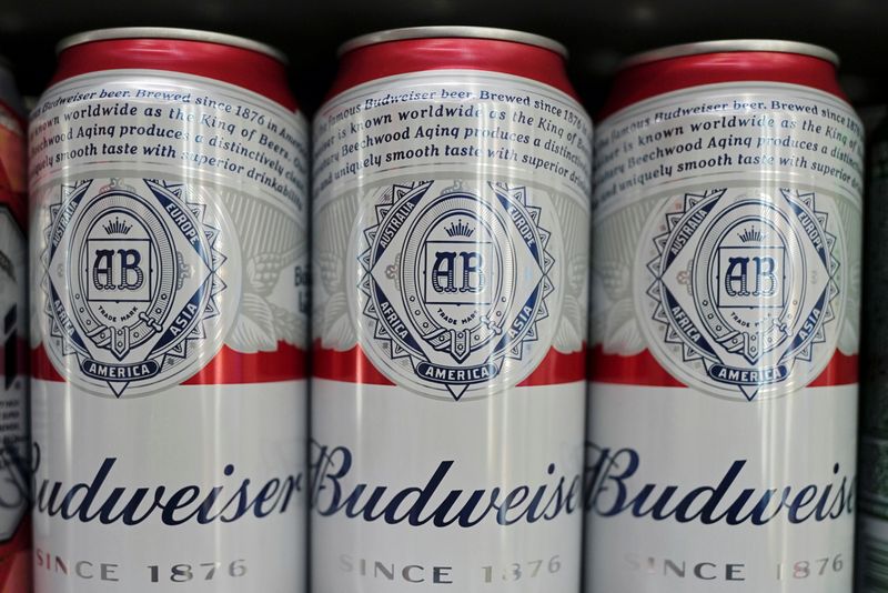 Cans of Budweiser beer are displayed on a supermarket shelf