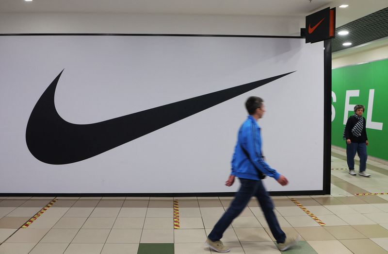 People walk past a closed store of Nike in Saint
